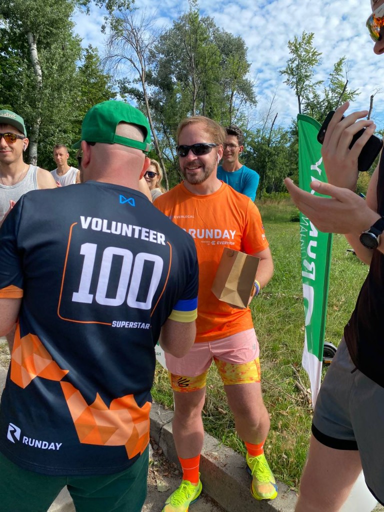 Volunteer receiving a 100-run milestone award
